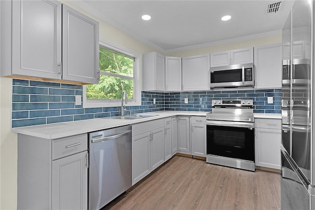 kitchen featuring white cabinetry, sink, stainless steel appliances, and light hardwood / wood-style floors