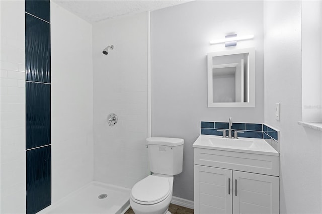 bathroom with a shower, vanity, a textured ceiling, and toilet