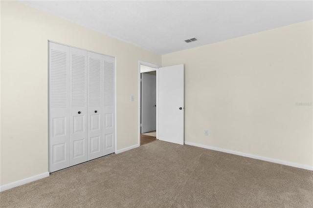 unfurnished bedroom featuring carpet and a closet