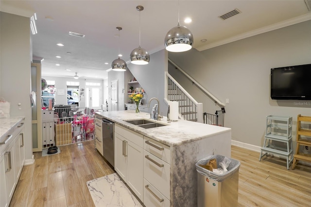 kitchen featuring a center island with sink, light stone counters, white cabinets, dishwasher, and light hardwood / wood-style flooring