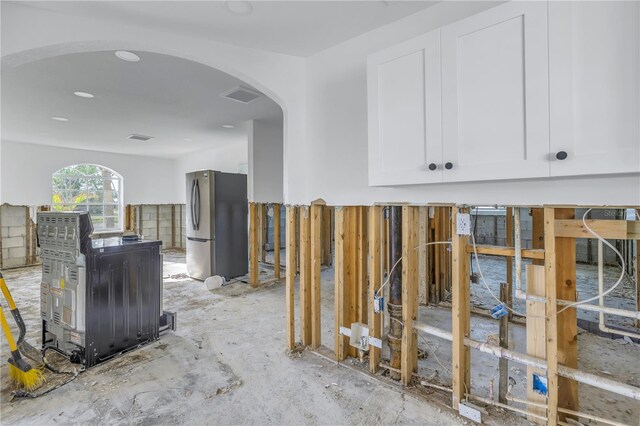 interior space featuring white cabinets and stainless steel refrigerator