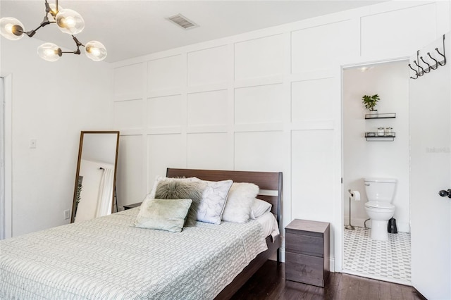 bedroom with a chandelier, dark hardwood / wood-style floors, and ensuite bathroom