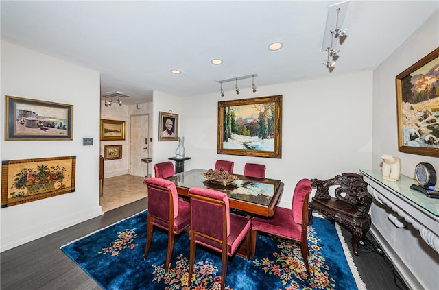 dining room with dark hardwood / wood-style floors and rail lighting