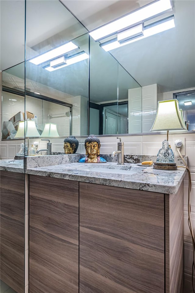 bathroom featuring vanity, a shower with shower door, and vaulted ceiling