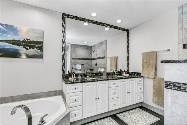 full bath with double vanity, recessed lighting, a sink, tiled shower, and a bath