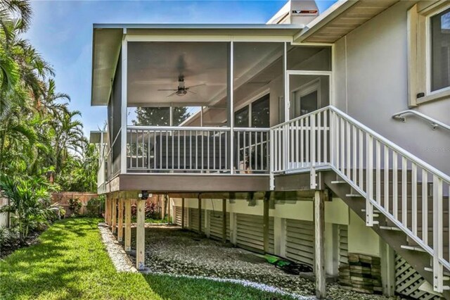 rear view of house with a yard, stairway, and a sunroom