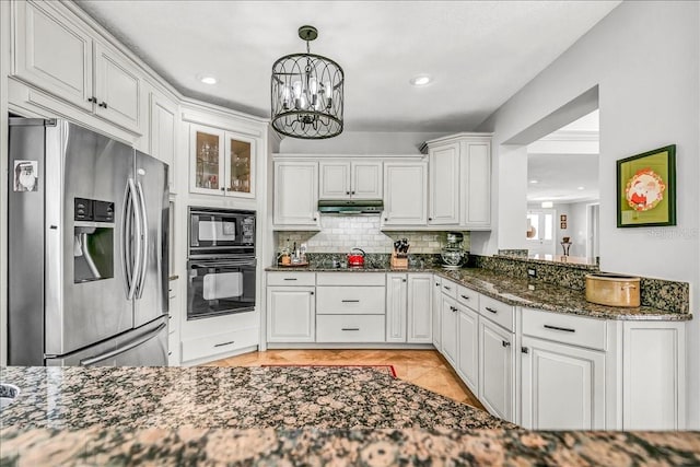 kitchen with under cabinet range hood, white cabinetry, dark stone counters, black appliances, and tasteful backsplash