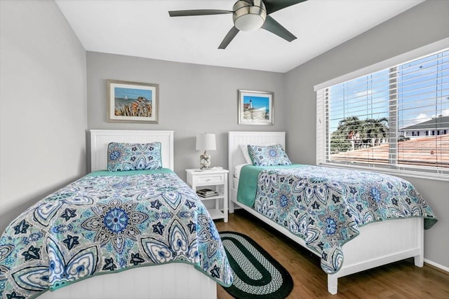 bedroom featuring wood finished floors, a ceiling fan, and baseboards