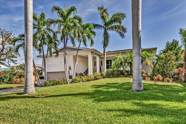 view of front facade with a garage, a front lawn, and stucco siding