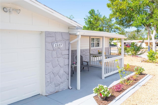 entrance to property with covered porch and a garage