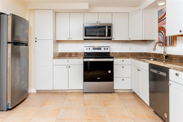 kitchen featuring white cabinetry, appliances with stainless steel finishes, and dark stone countertops