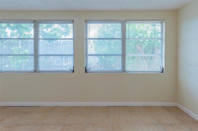 tiled spare room with a wealth of natural light