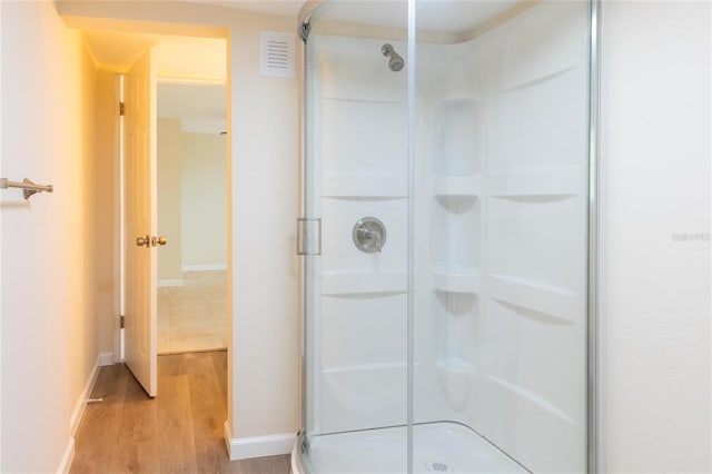 bathroom featuring hardwood / wood-style flooring and a shower with shower door