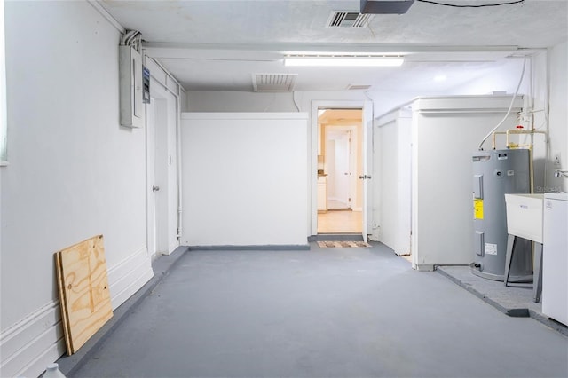 basement featuring electric panel and electric water heater