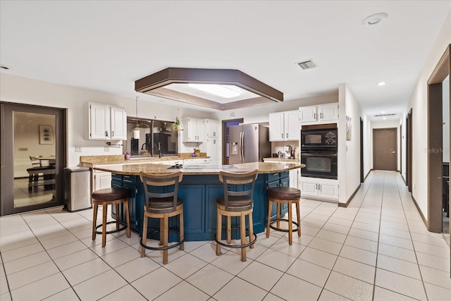 kitchen with white cabinets, black appliances, and a kitchen island