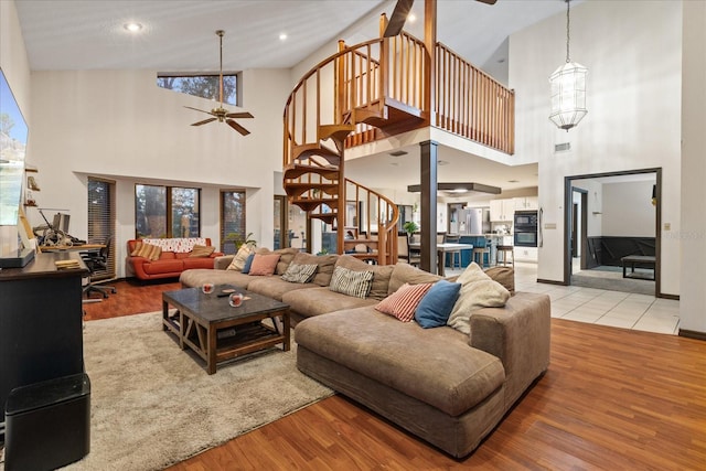 living room with high vaulted ceiling, light hardwood / wood-style floors, and ceiling fan