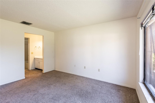 unfurnished bedroom featuring a textured ceiling, light carpet, and multiple windows