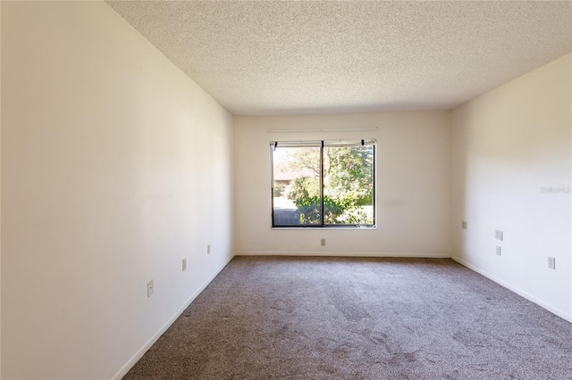 carpeted empty room featuring a textured ceiling