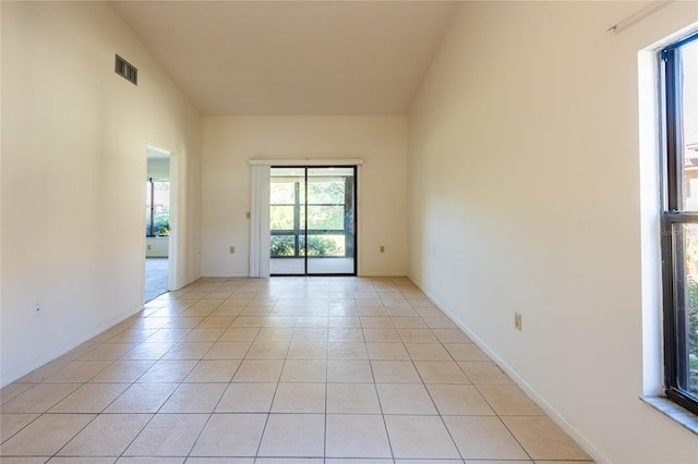 tiled spare room with vaulted ceiling