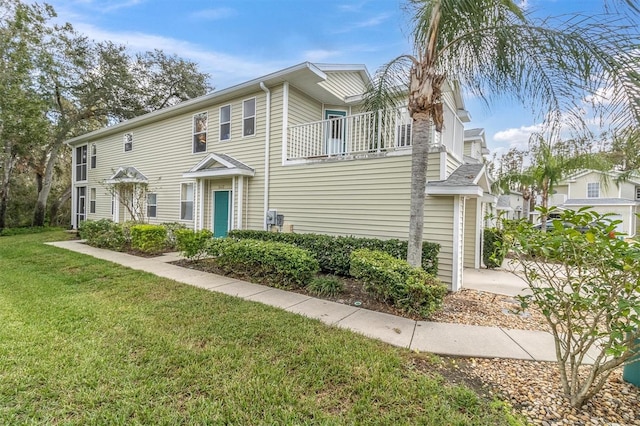 multi unit property with a front yard and a balcony