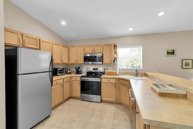 kitchen with light brown cabinets, lofted ceiling, sink, light tile patterned floors, and stainless steel appliances