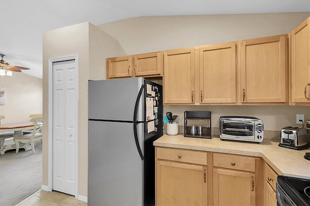 kitchen featuring ceiling fan, light brown cabinets, stainless steel appliances, and lofted ceiling