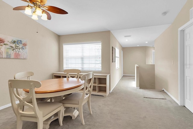 carpeted dining area with ceiling fan