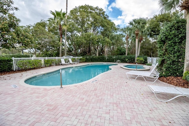 view of pool with a community hot tub and a patio