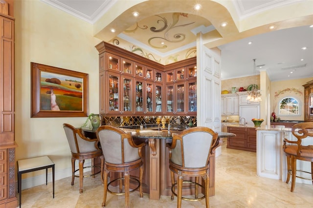 101 12th St E, Tierra Verde, FL 33715 - bar area with ornamental molding, decorative backsplash, a sink, recessed lighting, and arched walkways