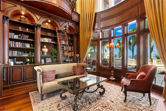 101 12th St E, Tierra Verde, FL 33715 - sitting room with wood finished floors, a towering ceiling, and built in shelves
