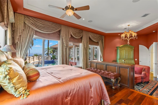 bedroom featuring access to outside, multiple windows, a tray ceiling, hardwood / wood-style floors, and ceiling fan with notable chandelier