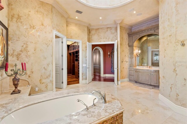 101 12th St E, Tierra Verde, FL 33715 - bathroom with ornamental molding, vanity, a garden tub, and baseboards