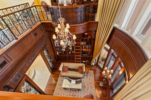 staircase featuring hardwood / wood-style floors, a towering ceiling, and a notable chandelier