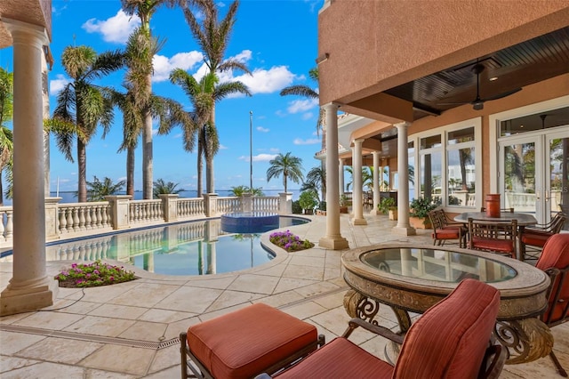 view of swimming pool featuring ceiling fan, a patio area, and french doors