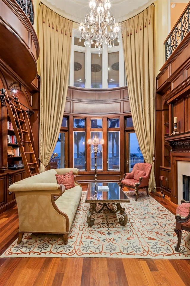 101 12th St E, Tierra Verde, FL 33715 - sitting room with a chandelier, wood finished floors, a fireplace, and a towering ceiling