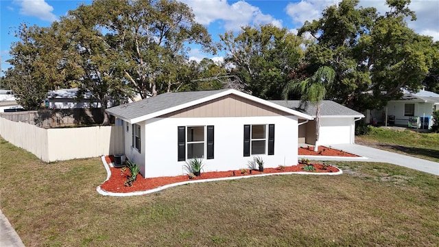 view of front of property featuring central AC unit, a garage, and a front yard