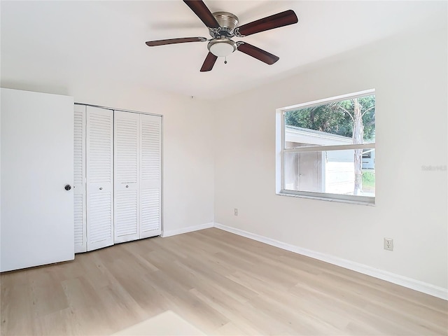 unfurnished bedroom featuring light wood-type flooring, a closet, and ceiling fan