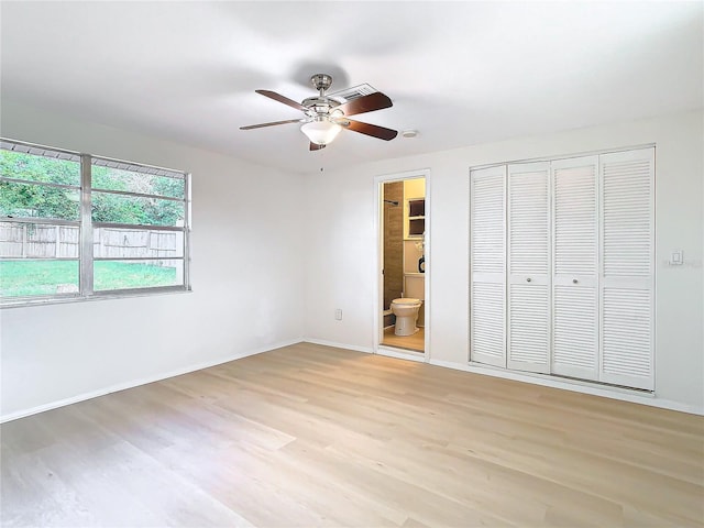 unfurnished bedroom with ceiling fan, light hardwood / wood-style floors, a closet, and ensuite bath