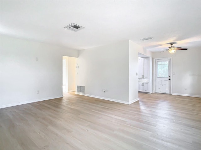 empty room with ceiling fan and light hardwood / wood-style floors