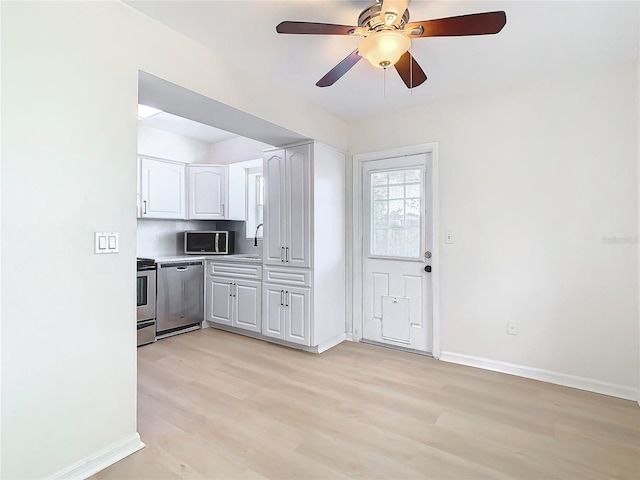 kitchen featuring white cabinets, sink, light hardwood / wood-style flooring, ceiling fan, and appliances with stainless steel finishes