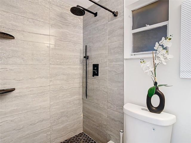 bathroom featuring toilet and tiled shower