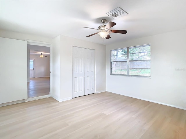 unfurnished bedroom featuring light wood-type flooring, a closet, and ceiling fan