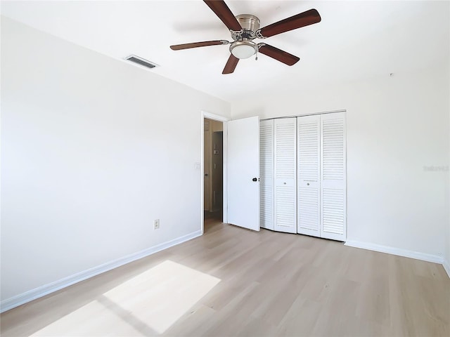 unfurnished bedroom with ceiling fan, a closet, and light hardwood / wood-style flooring