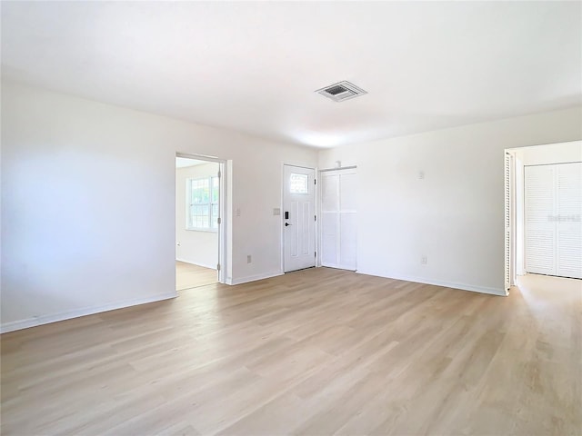 empty room featuring light hardwood / wood-style floors and a barn door