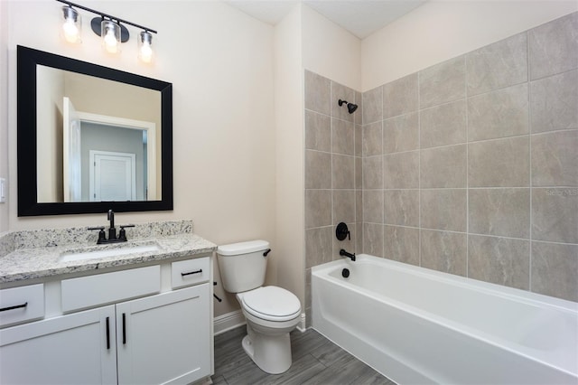 full bathroom with tiled shower / bath, toilet, and vanity