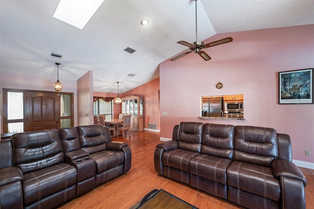 living room with ceiling fan, wood-type flooring, and lofted ceiling