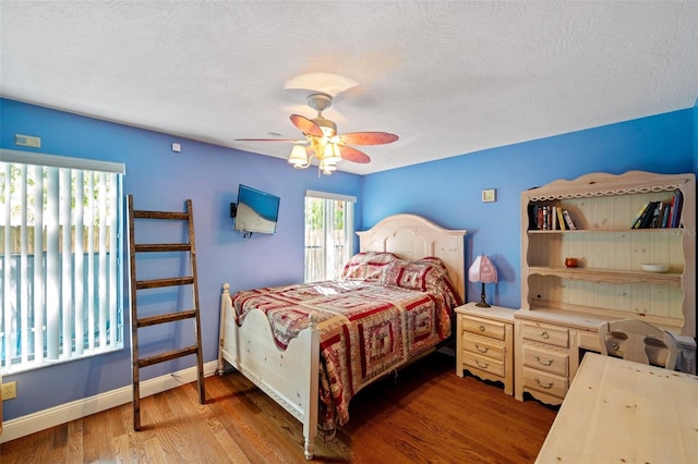 bedroom with hardwood / wood-style floors, ceiling fan, and a textured ceiling