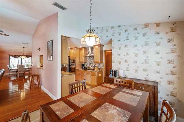 dining room featuring hardwood / wood-style floors and vaulted ceiling