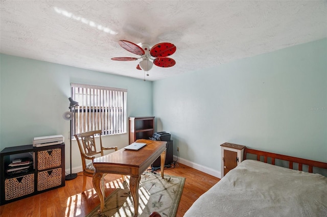 bedroom with a textured ceiling, light wood-type flooring, and ceiling fan