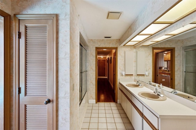 bathroom with tile patterned flooring, vanity, and combined bath / shower with glass door